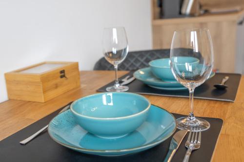 慕尼黑SweetHome - super Zentral und modern, Küche, WiFi的一张桌子,上面放着两个蓝色的碗和酒杯