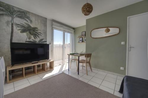 尼姆La Palm Room ~ Balcon ~ Parking ~ Climatisation的客厅配有平面电视和桌子。