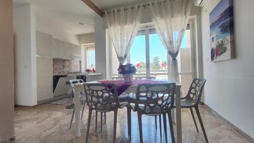 奥特朗托Miramare Apartments的一间带桌椅和窗户的用餐室