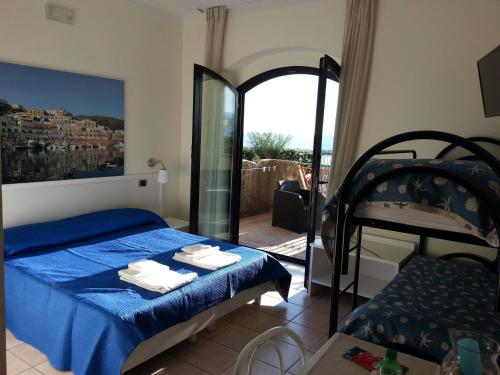 福尔米亚Hotel Tirreno Formia的一间卧室设有蓝色的床和一个阳台