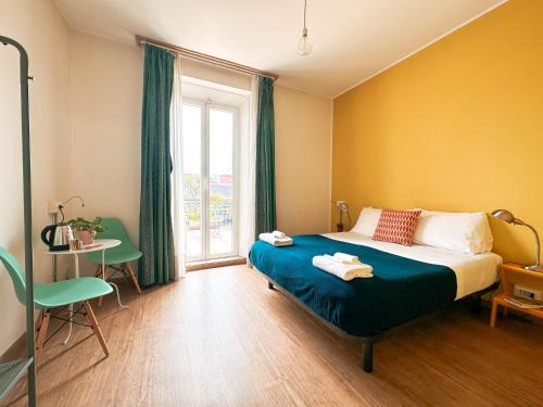 米兰Ostello Bello Milano Centrale的一间卧室配有一张床、一张桌子和一个窗户。