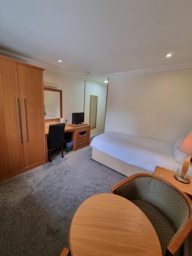 达宁顿堡Kegworth Hotel & Conference Centre的配有一张床、一张桌子和一张桌子的酒店客房