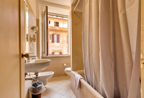 罗马特米诺酒店的一间带水槽和卫生间的浴室以及窗户。