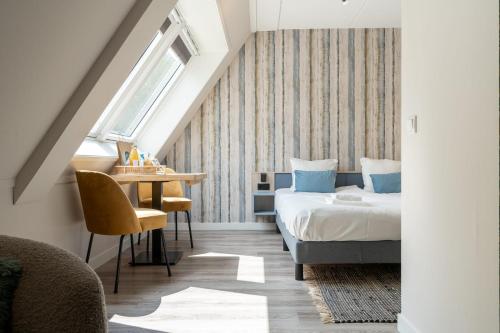 东卡佩勒Hello Zeeland - Appartement Duno Lodge M的一间卧室配有一张床、一张桌子和一个窗户。