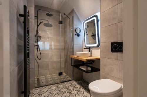 东卡佩勒Hello Zeeland - Appartement Duno Lodge M的一间带卫生间、水槽和镜子的浴室