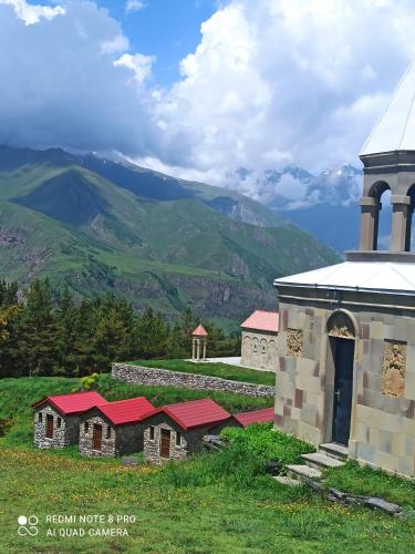 卡兹贝吉卡兹贝吉水晶旅馆的教堂和山丘的背景