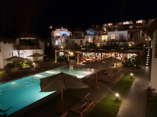 维加伊托Llapa House的夜间游泳池,配有遮阳伞和椅子