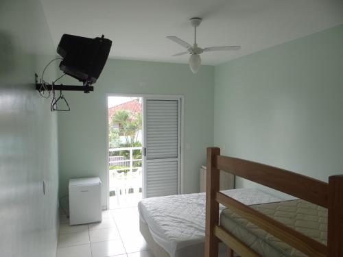 瓜拉图巴生活住宅一室公寓的卧室配有一张床,墙上配有电视。