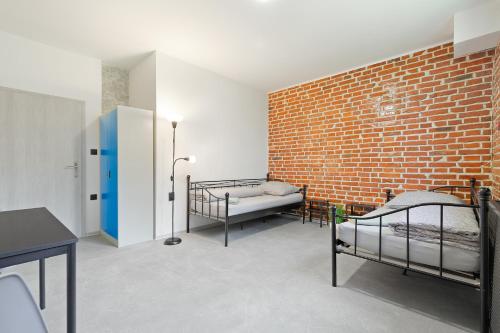 俄斯特拉发Hostel na Šalamouně的一间设有两张床和砖墙的房间