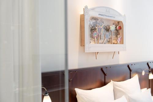 杜塞尔多夫Ruby Leni Hotel Dusseldorf的一张带白色枕头的床和一张墙上的照片