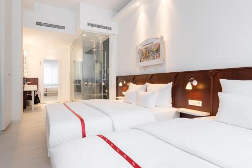 杜塞尔多夫Ruby Leni Hotel Dusseldorf的一间卧室配有两张带白色枕头的床