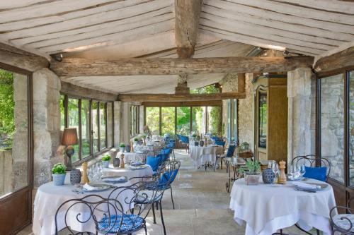 梅内尔伯La Bastide de Marie, Maisons et Hôtels Sibuet的用餐室配有白色的桌子和蓝色的椅子