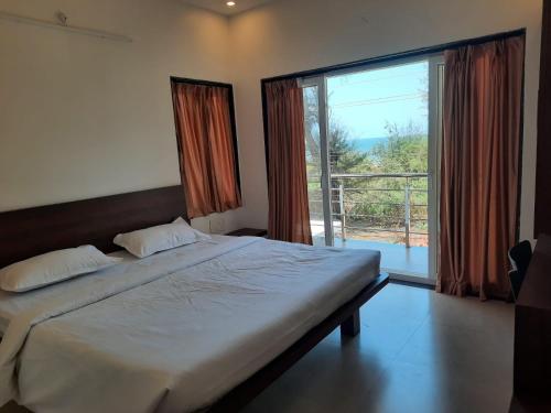 马尔万Raapan Beach Resort的一间卧室设有一张大床和一个大窗户