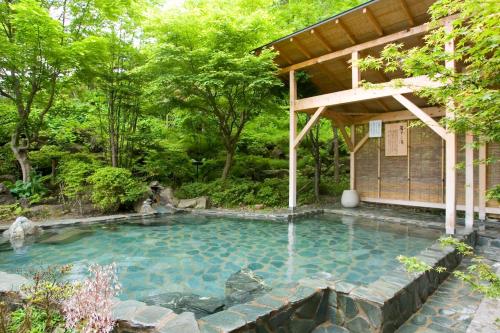 盛冈大观酒店的花园内的游泳池,带凉亭