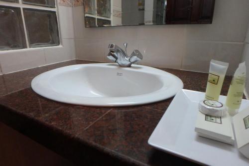 卡伦海滩天堂客栈的浴室设有白色水槽和镜子