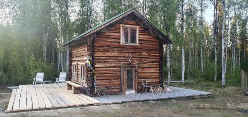 JörnGemütliche Blockhütte mit Außentoilette und Badezimmer im Haupthaus的小木屋 - 带2把椅子和木甲板