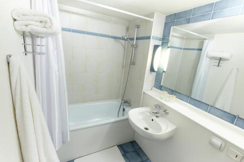 瓦雷讷沃泽勒钟楼内维北瓦尔纳瓦泽尔酒店的一间带水槽、浴缸和卫生间的浴室
