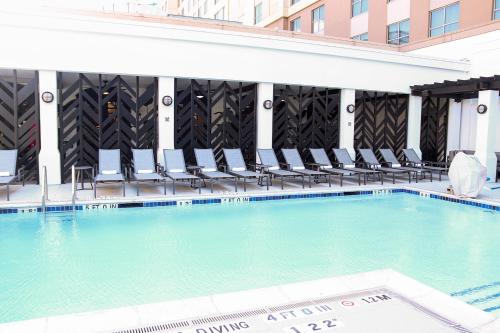 休斯顿The Chifley Houston, Tapestry Collection by Hilton的大楼内带椅子的大型游泳池