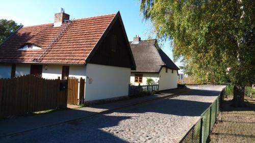 KrumminHaus am Wiek的白色的房子,有棕色的屋顶和栅栏