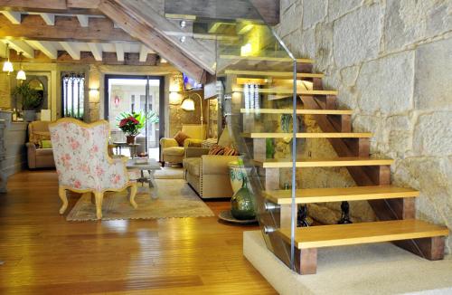 坎巴多斯Hotel Real Cambados的一间带楼梯和石墙的客厅