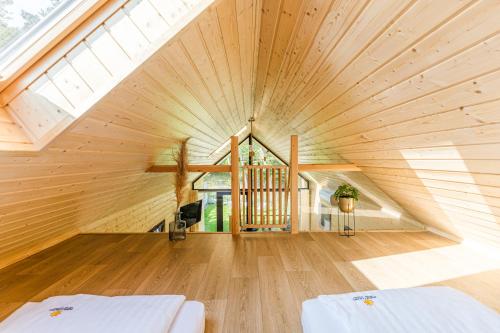 凯蒂赖贝西Bursztynowo的阁楼卧室设有大型木制天花板