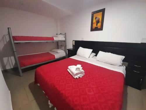 马德普拉塔阿尔蒂科酒店的一间卧室设有两张双层床和红色毯子