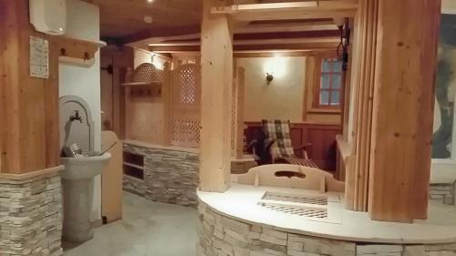 卢塔戈Hotel Tiroler Adler的客厅设有石制壁炉和水槽。