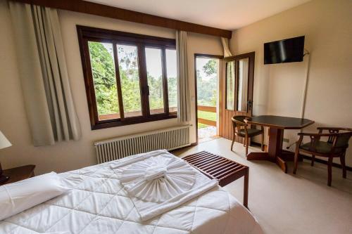 哥伦布埃斯坦西亚贝塔尼亚酒店的一间卧室配有一张床、一张桌子和一个窗户。