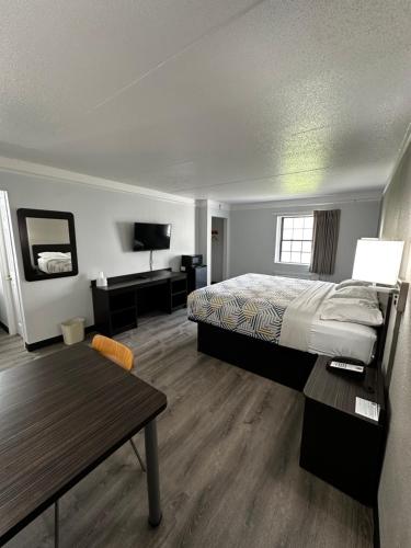 黑泽尔伍德Motel 6-Hazelwood, MO的酒店客房配有一张床铺和一张桌子。