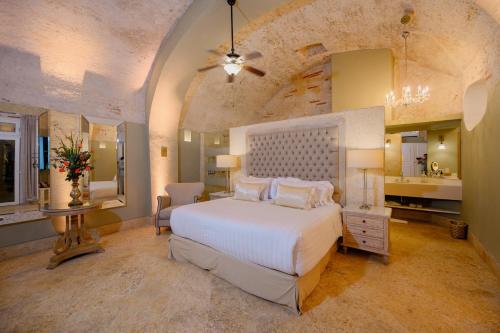卡塔赫纳Hotel Casa del Gobernador的一间带白色大床的卧室和一间浴室