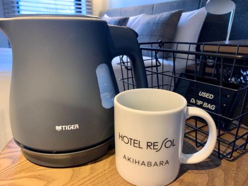 东京Hotel Resol Akihabara的咖啡壶和桌子上的咖啡杯