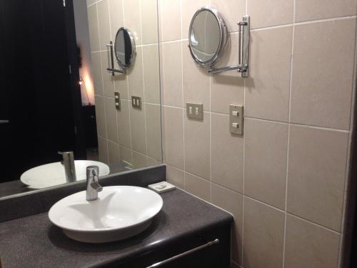 马那瓜Hotel Brandts Ejecutivo Los Robles的浴室设有水槽和墙上的两面镜子