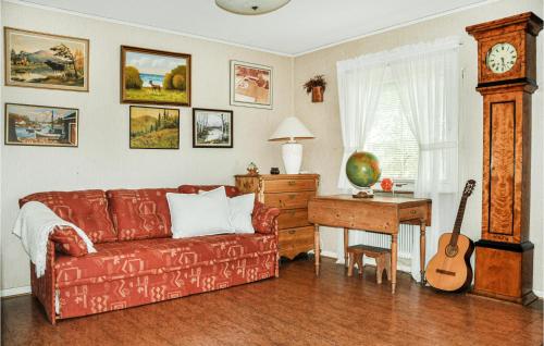 赛夫勒Nice Home In Sffle With House A Panoramic View的客厅配有沙发和带吉他桌的书桌