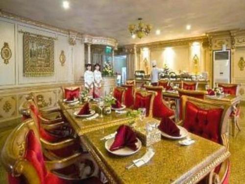 KalanganHotel Utami的餐厅设有长桌和红色椅子