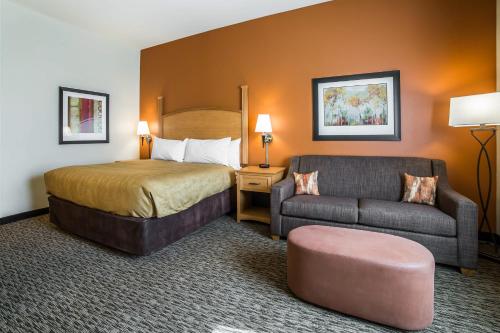 西德尼MainStay Suites Sidney - Medical Center的酒店客房,配有床和沙发