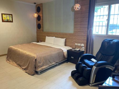 高雄金银岛汽车旅馆-仁武店的配有一张床和一把椅子的酒店客房