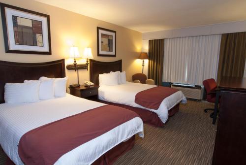 匹兹堡Lamplighter Inn & Suites Pittsburg的酒店客房设有两张床和电视。
