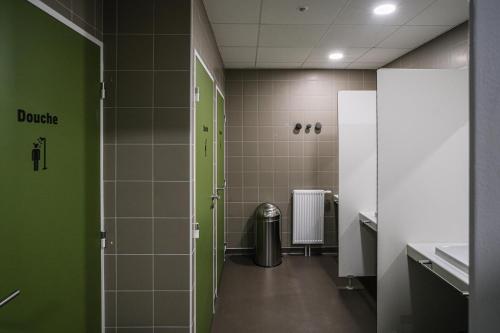 克莱蒙费朗Auberge de jeunesse HI Clermont-Ferrand的浴室铺有绿色的白色瓷砖,配有垃圾桶