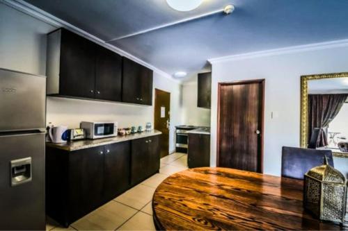 伯诺尼ANEW Hotel & Convention Centre OR Tambo Johannesburg的一间厨房,内设一张木桌