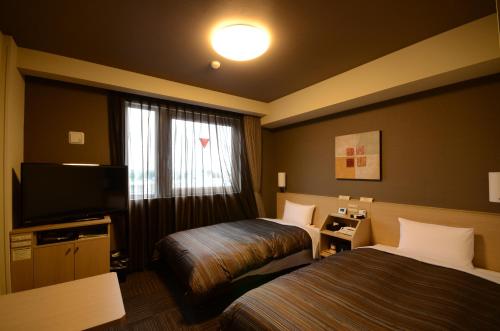 安中安中茹塔酒店的酒店客房设有两张床和电视。