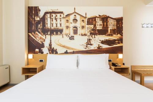 米兰B&B Hotel Milano La Spezia的卧室配有白色的床和墙上的绘画作品