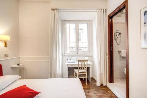 罗马B&B Hotel Roma Italia Viminale的一间卧室配有一张床、一张书桌和一个窗户。