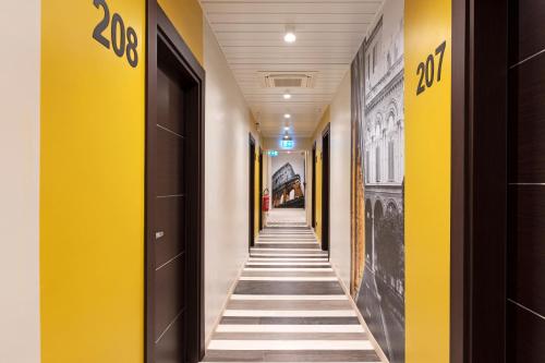 罗马B&B Hotel Roma San Lorenzo Termini的一条空的走廊,有黄色和白色的墙壁