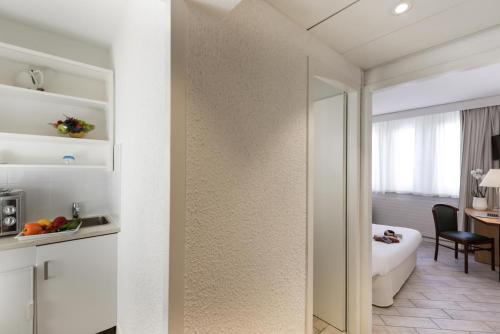日内瓦日内瓦中心一室公寓的一间带镜子的浴室和一间带桌子的房间