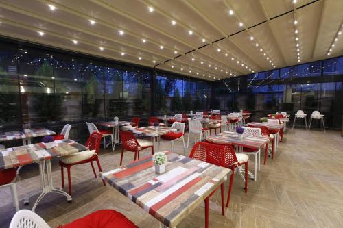 伊兹密尔布卡公寓酒店的餐厅设有桌椅和大窗户。