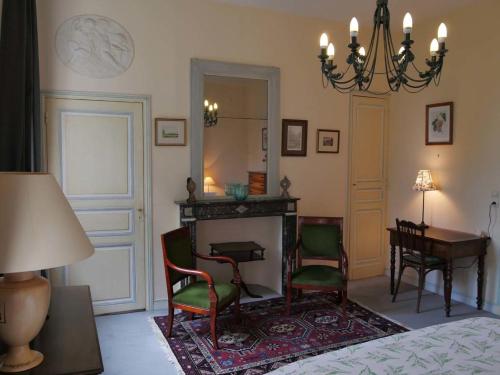 赫恩Chambres d'hôtes Château de Courcelette的一间卧室设有壁炉和桌椅。
