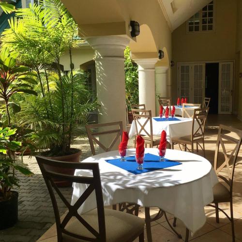 圣费尔南多The Royal Hotel的两张桌子,上面有红色的带子,放在一个庭院