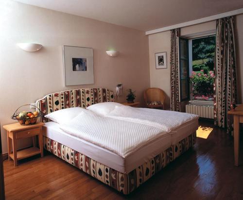 日村皮诺曹酒店的一间卧室设有一张大床和一个窗户。