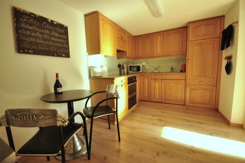 格尔兹维尔西加里河滨公寓的厨房配有木制橱柜和1张带1瓶葡萄酒的桌子。
