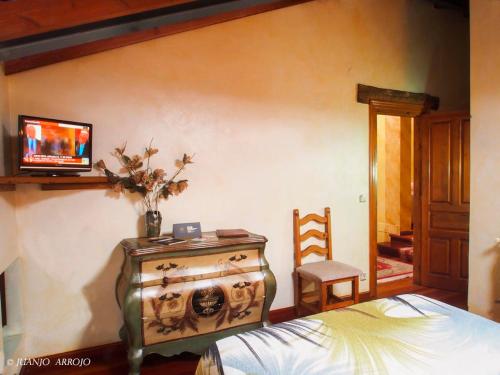 梅斯塔斯德康苏库瓦斯乡间酒店的一间卧室配有一张床,墙上配有电视